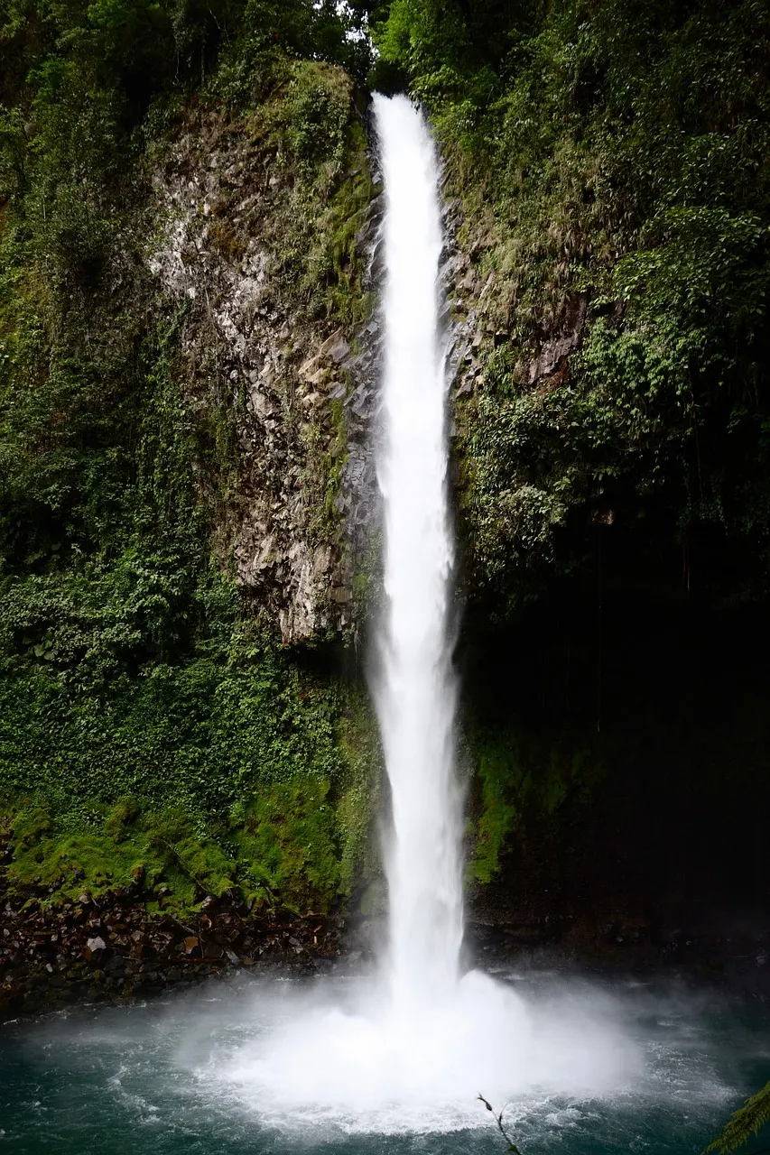 Hoge waterval die langs een begroeide rotswand omlaag valt in Rincón de la Vieja